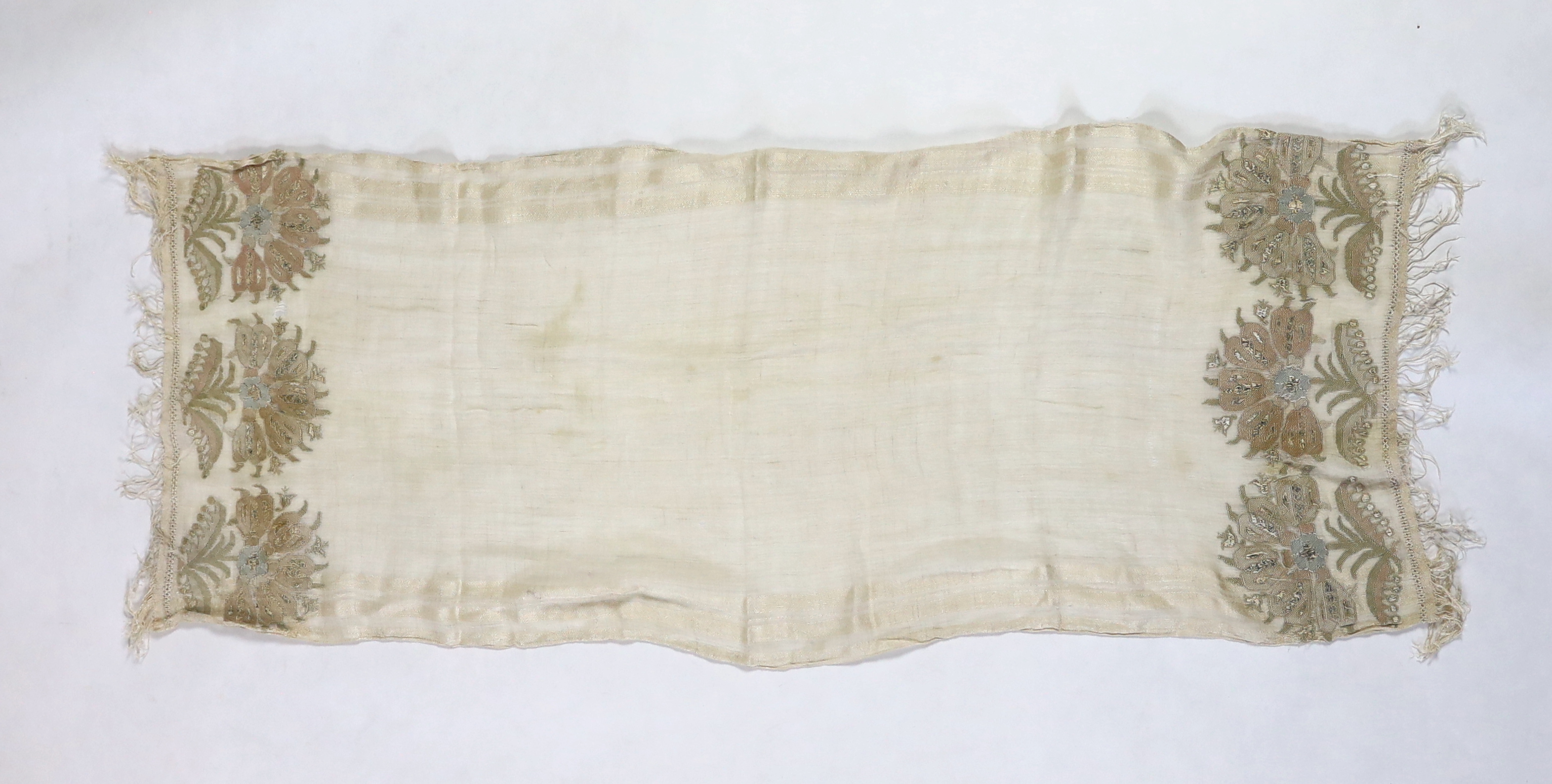 A 19th century Turkish towel, embroidered with flower motifs, in pastel shades, with fine silk fringing embroidered onto a fine hand spun linen, woven with stripes to each side, 48cm wide, 120cm long